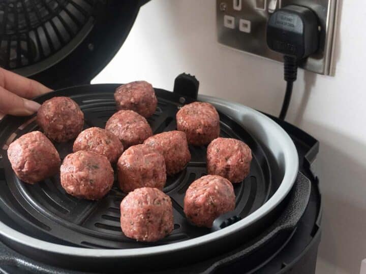 Raw Meatballs Being Placed Into An Air fryer