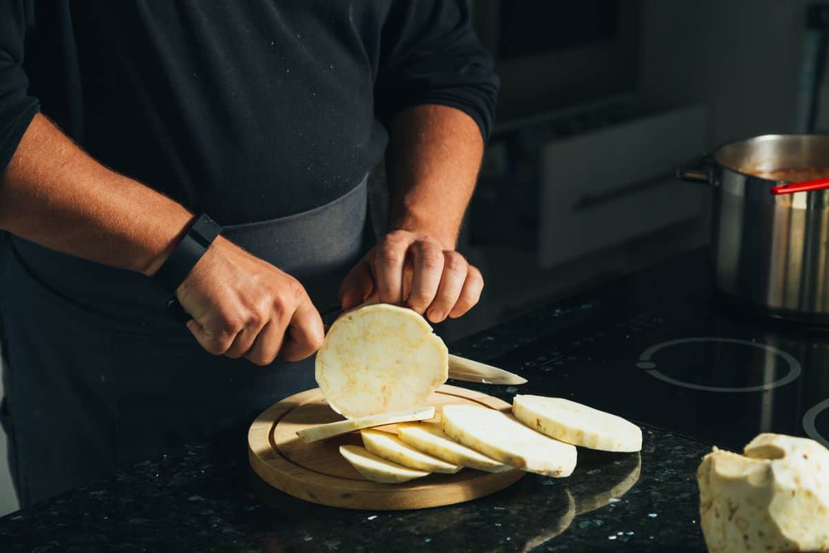 man cutting celery root