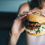woman holding blue cheese burger